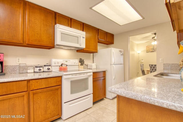 kitchen featuring ceiling fan, sink, light tile patterned flooring, and white appliances