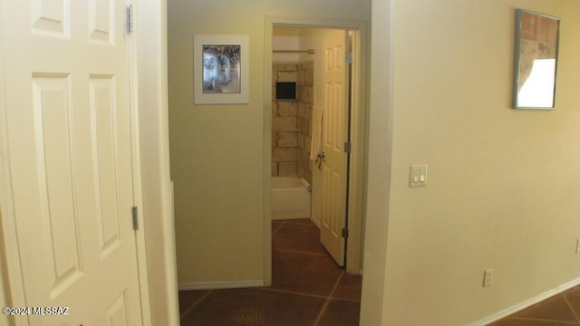 hall featuring dark tile patterned floors