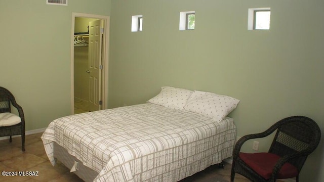 bedroom with a walk in closet, a closet, and tile patterned floors