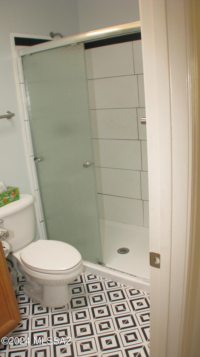 bathroom featuring walk in shower and toilet