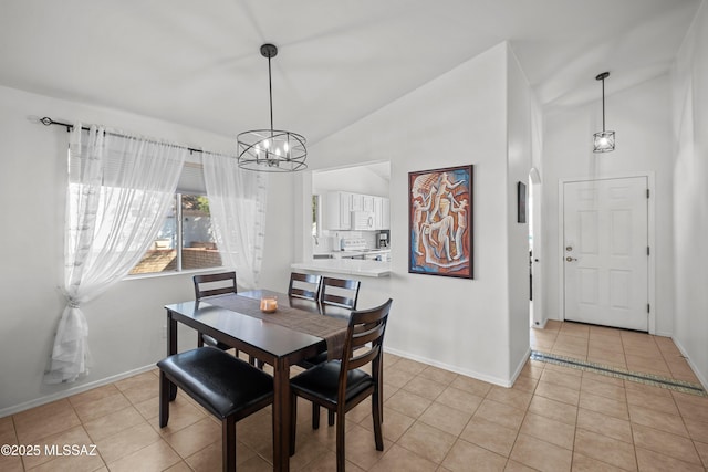 tiled dining room with lofted ceiling and a notable chandelier