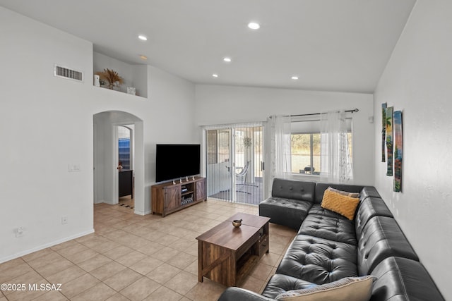 living room featuring light tile patterned floors and high vaulted ceiling