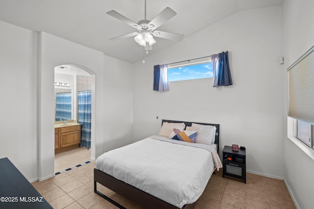 bedroom with vaulted ceiling, ceiling fan, ensuite bathroom, and light tile patterned flooring