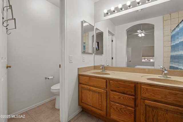 bathroom with ceiling fan, toilet, vanity, and tile patterned flooring