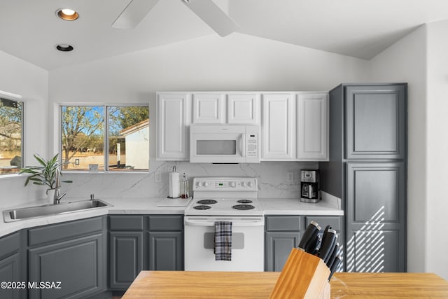 kitchen with white appliances, gray cabinets, and lofted ceiling