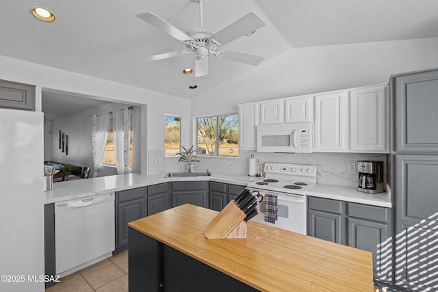 kitchen featuring ceiling fan, vaulted ceiling, sink, white appliances, and gray cabinetry