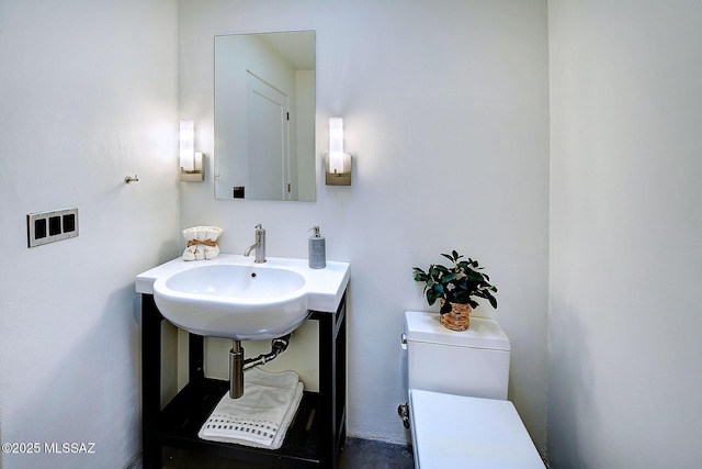 half bathroom featuring a sink and toilet