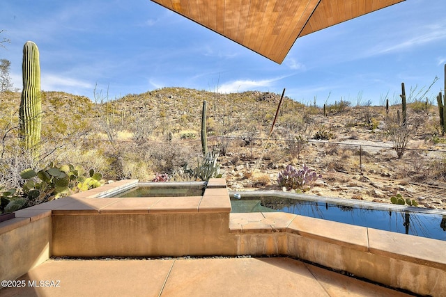 exterior space featuring a hot tub, a swimming pool, and fence