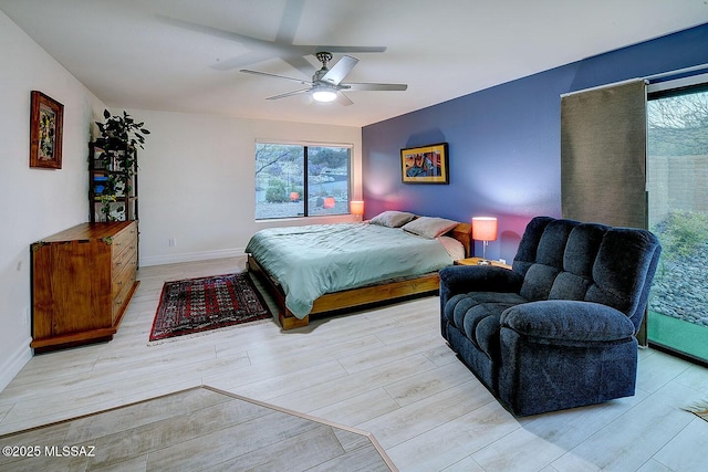 bedroom with multiple windows, ceiling fan, and light hardwood / wood-style floors