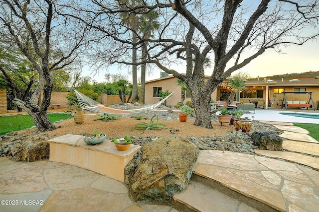 yard at dusk featuring a patio