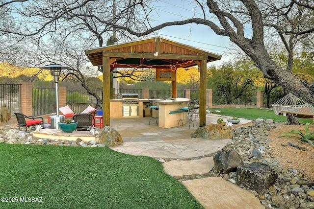 view of patio / terrace featuring a bar, area for grilling, exterior kitchen, and a gazebo