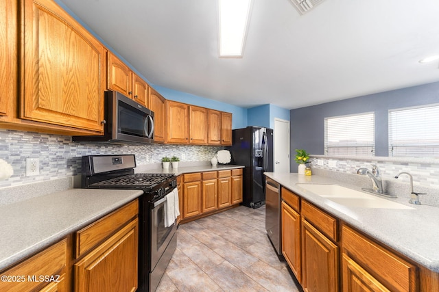 kitchen with tasteful backsplash, appliances with stainless steel finishes, and sink