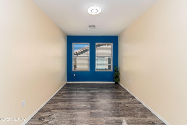 unfurnished room with dark wood-type flooring