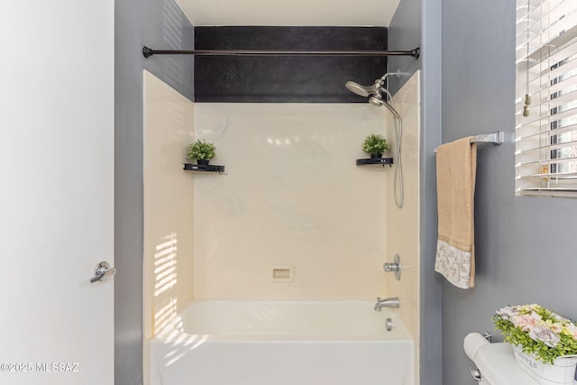 bathroom with tub / shower combination and toilet