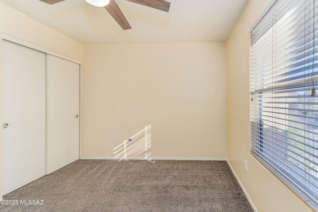 unfurnished bedroom featuring ceiling fan, a closet, and carpet flooring