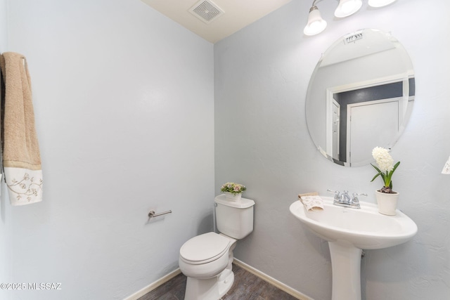 bathroom with hardwood / wood-style flooring and toilet