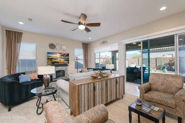 living room with recessed lighting, light tile patterned floors, visible vents, a ceiling fan, and a stone fireplace