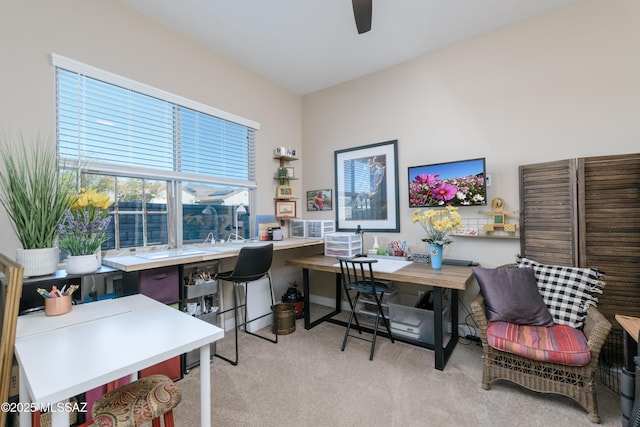 office with a ceiling fan and light carpet