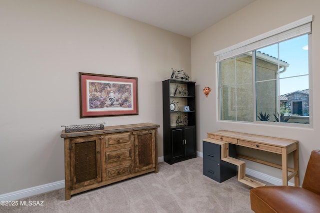 home office featuring baseboards and light carpet