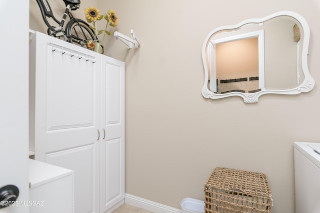 laundry area with baseboards, cabinet space, and washer / clothes dryer