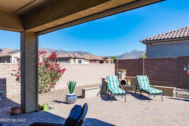 view of patio / terrace with a mountain view and a fenced backyard