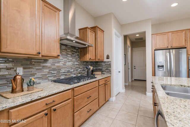 kitchen featuring visible vents, stainless steel appliances, wall chimney range hood, backsplash, and light tile patterned floors
