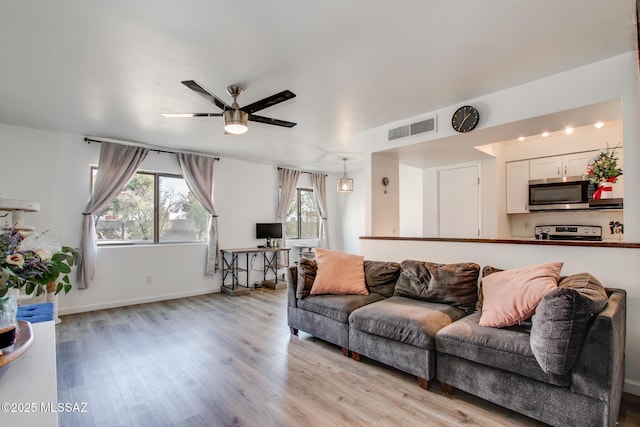 living room with ceiling fan and light hardwood / wood-style floors