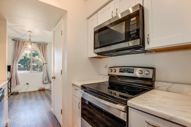 kitchen featuring white cabinetry, pendant lighting, stainless steel appliances, and hardwood / wood-style flooring