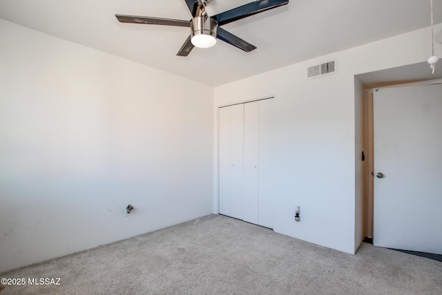 unfurnished bedroom with light carpet, a closet, and ceiling fan