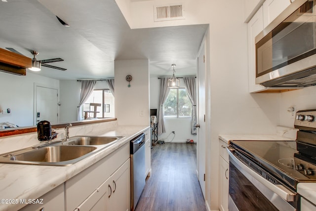 kitchen featuring stainless steel appliances, white cabinetry, sink, and dark wood-type flooring