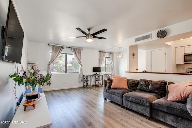 living room featuring light hardwood / wood-style flooring and ceiling fan