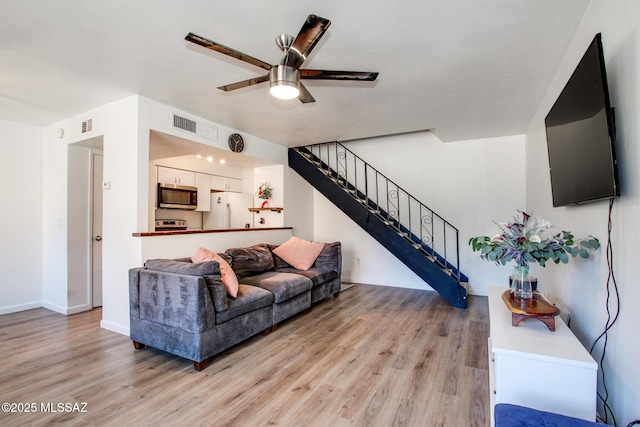 living room with light hardwood / wood-style flooring and ceiling fan