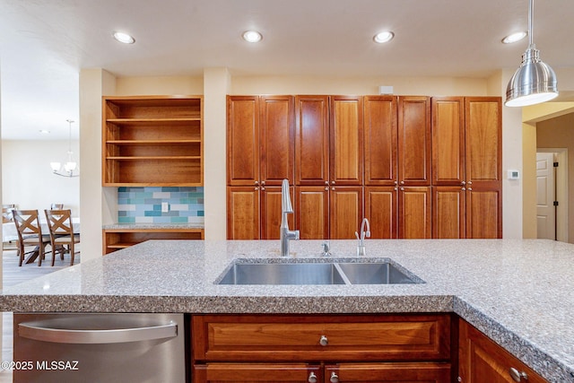 kitchen with decorative light fixtures, dishwasher, sink, and backsplash