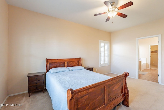 bedroom featuring connected bathroom, light colored carpet, and ceiling fan