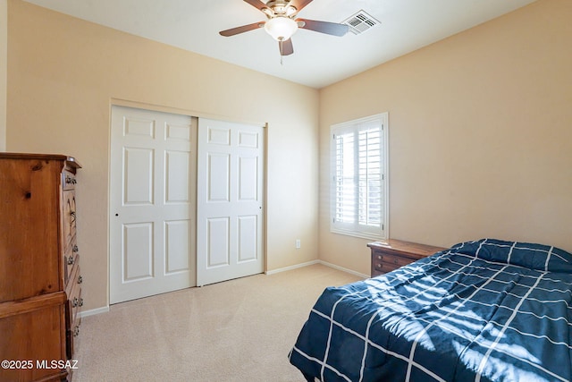 carpeted bedroom with ceiling fan and a closet