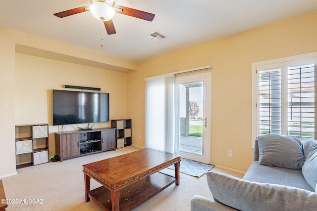 carpeted living room with ceiling fan and plenty of natural light