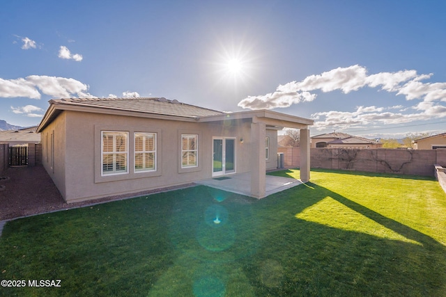 back of property featuring a yard and a patio area