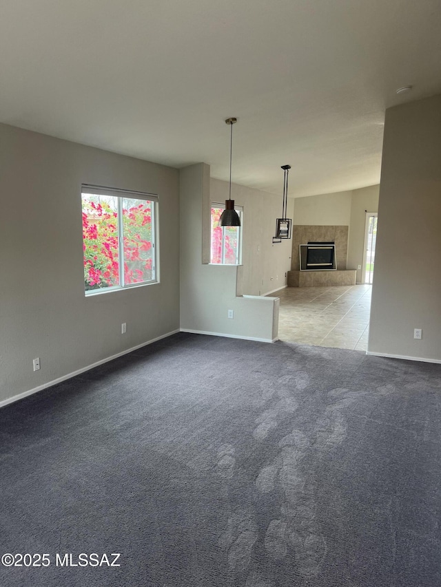 unfurnished living room featuring light carpet and a tiled fireplace