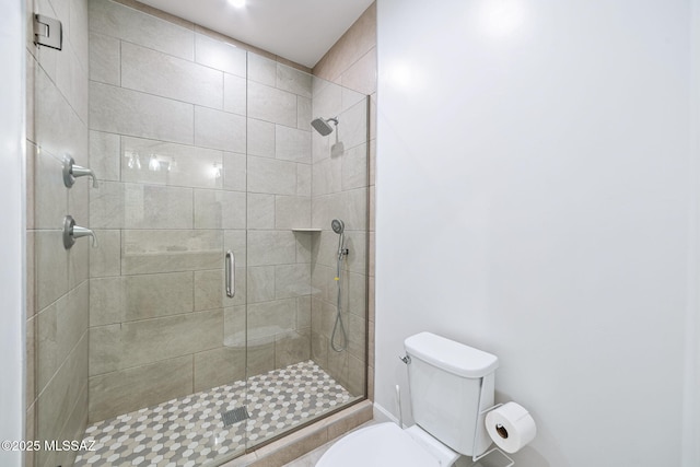 bathroom featuring toilet and a shower with shower door