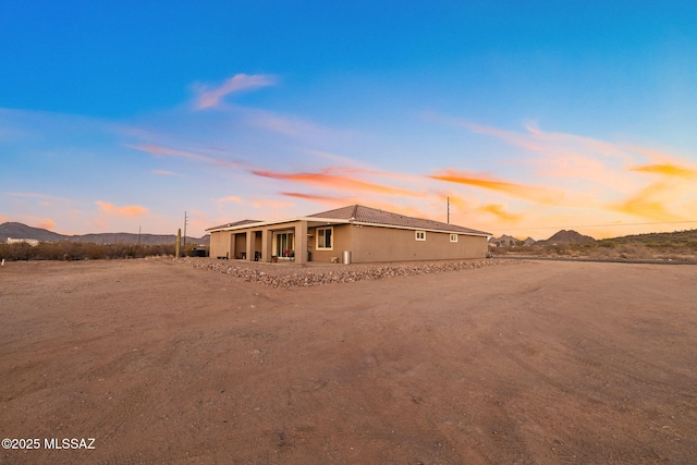 back house at dusk featuring a mountain view