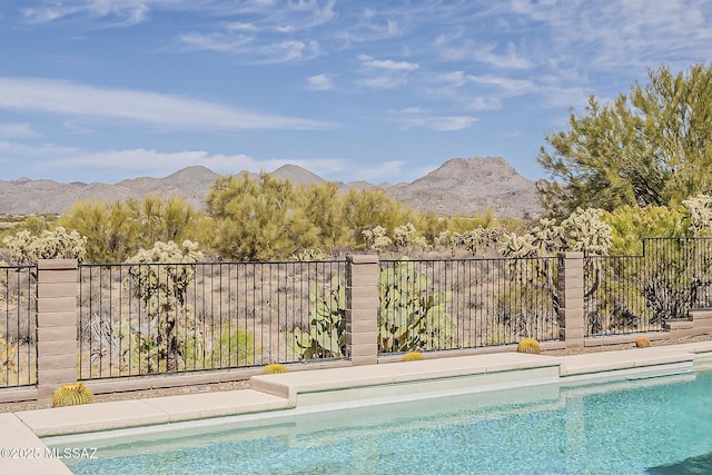 view of pool featuring a fenced in pool, fence, and a mountain view