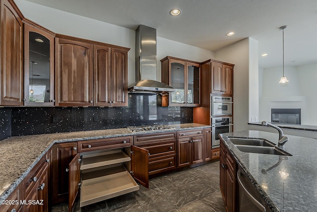 kitchen with dark stone counters, a sink, appliances with stainless steel finishes, wall chimney exhaust hood, and marble finish floor