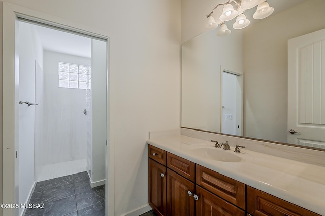 bathroom with vanity, a shower, and baseboards