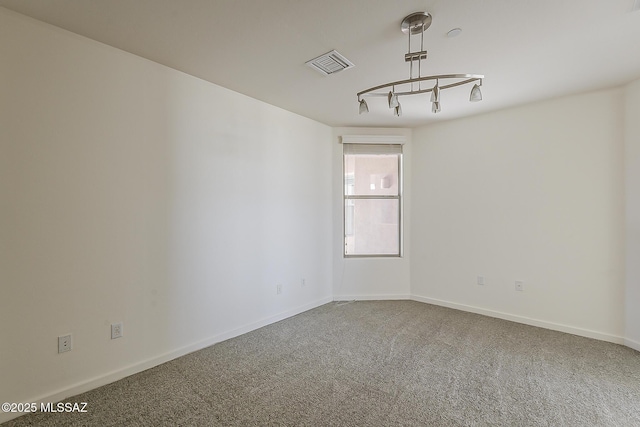 carpeted spare room featuring baseboards and visible vents