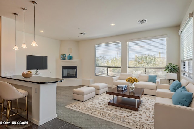 living room with visible vents, recessed lighting, a fireplace, and dark carpet