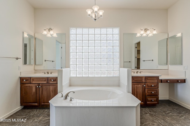 full bathroom with a bath, a chandelier, marble finish floor, and two vanities