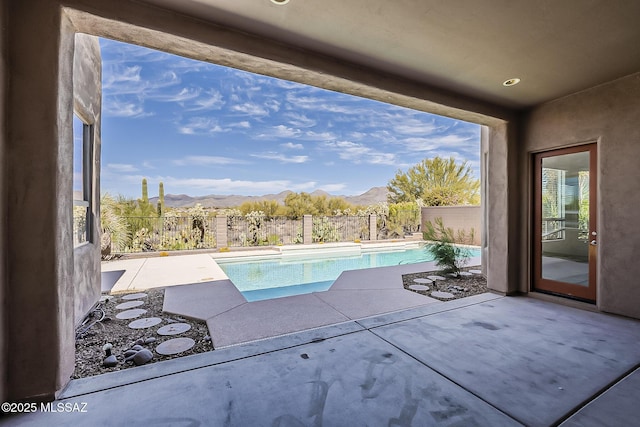 view of pool featuring a mountain view, a fenced in pool, a fenced backyard, and a patio area