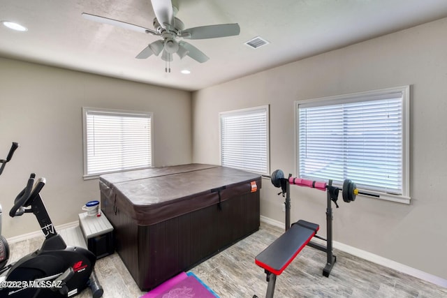 workout area with light hardwood / wood-style floors and ceiling fan