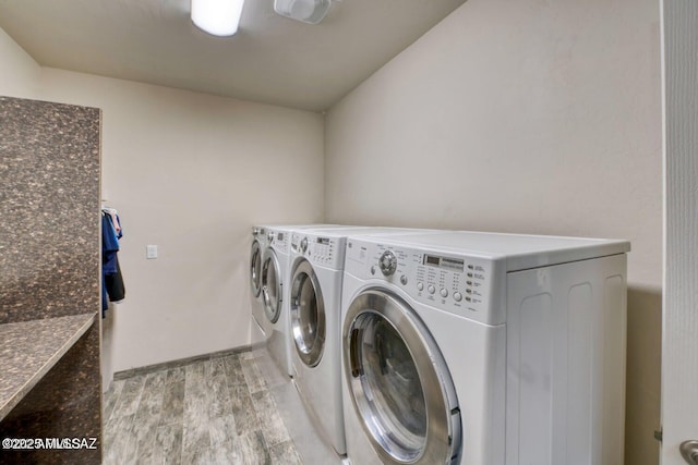 clothes washing area featuring light hardwood / wood-style floors and washing machine and clothes dryer