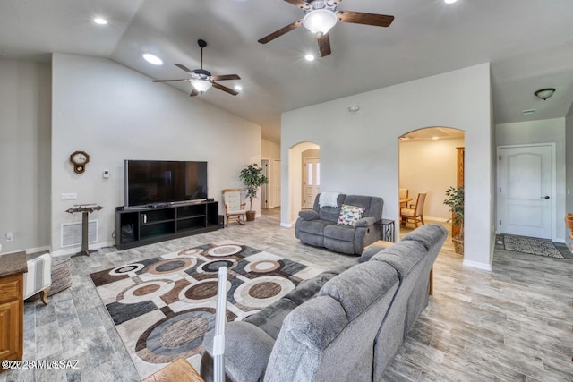 living room featuring vaulted ceiling, radiator heating unit, ceiling fan, and light hardwood / wood-style floors